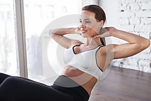 Young 20s woman doing crunches in gym