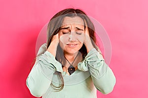 Young 25 year old student girl with headache and body discomfort, isolated on colored background