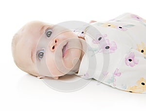 Young 3 month baby girl lying the ground isolated on a white background.