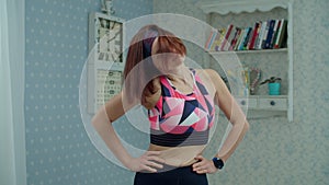 Young 30s woman in sportswear making fitness exercises at home. Female doing sports neck warm up before workout at home