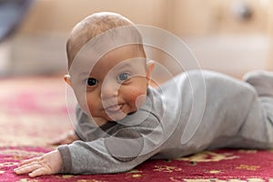 A young 4 month old white baby learns to crawl