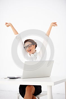 Young accountant at her desk with raised arms