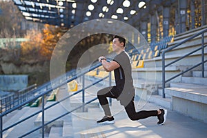 Young active asian fit man engaged in physical exercise stretching outdoor street. Male athlete in sportswear workout urban city