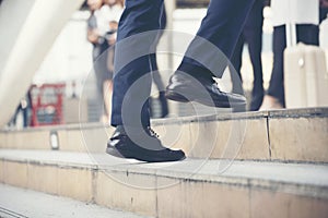 Young active business people walking up stair to go to work in modern city. Crowded group of people in big city lifestyle with