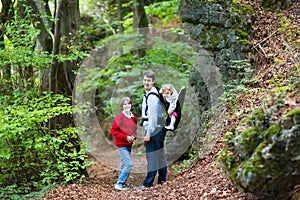 Young active father hiking in cliff and forest with kids