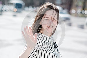 A young active girl waves her hand to say goodbye.