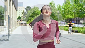 Young active motivated fit woman runner jogger running in urban city park.