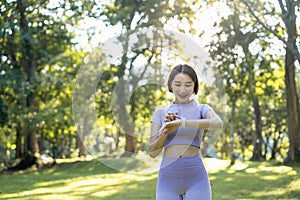 Young active sport woman using a smart watch to monitor her training progress after workout