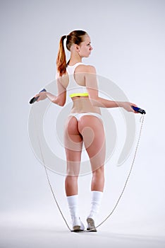 Young active woman with jump rope in studio