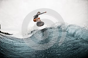 Young active woman surfs coolly on surf board and jumps on the wave photo