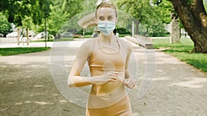 Young active woman wearing mask jogging in city park.