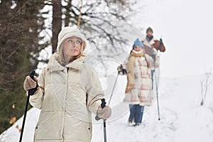 Young active woman in winterwear practicing Scandinavian walking