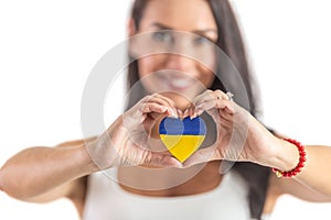 Young activist holding a heart in Ukraine colours representing love and empathy to attacked people. Isolated background