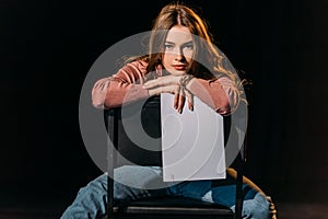 Young actress with scenario sitting on