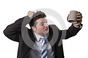 Young addict business man in suit and tie holding empty cup of coffee anxious