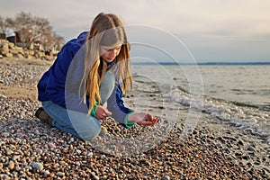 Young Adolescent Girl Collects Beautiful Rocks Pebbles and Shells on the Beach Along Georgian Bay