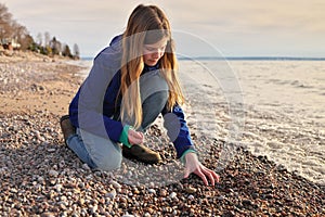 Young Adolescent Girl Collects Beautiful Rocks Pebbles and Shells on the Beach Along Georgian Bay