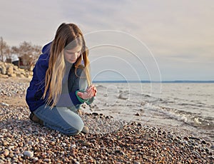 Young Adolescent Girl Collects Beautiful Rocks Pebbles and Shells on the Beach Along Georgian Bay