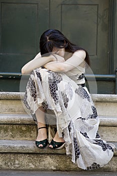 Young adorable depressed woman sitting on stairs