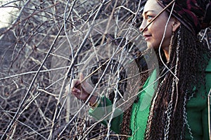 young adorable pretty girl with pigtails hairstyle smiling outside among trees