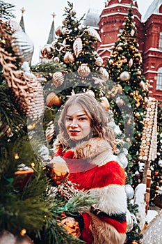 Young and adorable russian girl walking on Manezhnaya Square Moscow on the Red Square through winter holiday