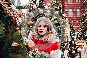 Young and adorable russian girl walking on Manezhnaya Square Moscow on the Red Square through winter holiday