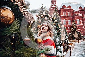 Young and adorable russian girl walking on Manezhnaya Square Moscow on the Red Square through winter holiday