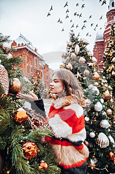 Young and adorable russian girl walking on Manezhnaya Square Moscow on the Red Square through winter holiday