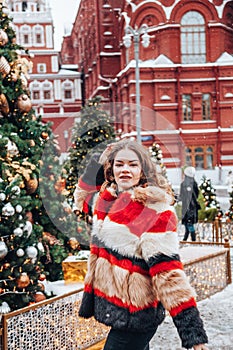 Young and adorable russian girl walking on Manezhnaya Square Moscow on the Red Square through winter holiday