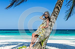 Young adorable woman at tropical sandy beach during Caribbean vacation