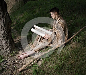 Man sitting on the grass and reading book