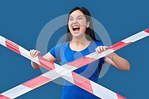 Young adult asian girl screaming, standing behind caution line