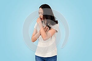 Young adult asian woman coughing, feels sore throat