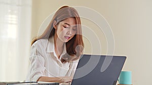 Young adult asian woman work at home office, open laptop computer and start working. Work from home life information technology