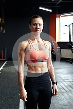 Young adult athlete woman with innovative wearable belt to monitoring heart rate