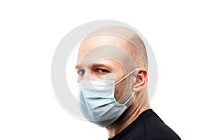 Young adult bald head man wearing respiratory protective medical mask