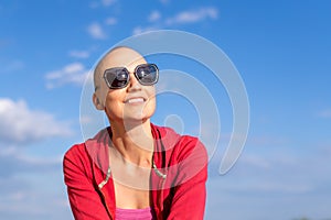 Young adult beautiful happy attractive caucasian bald shaved woman portrait in sunglases enjoy looking far away and