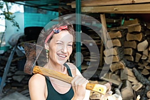 Young adult beautiful happy attractive caucasian brunette woman portrait have fun enjoy holding old rusty axe chopping