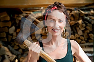 Young adult beautiful happy  attractive caucasian brunette woman portrait have fun enjoy holding old rusty axe chopping