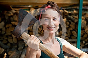 Young adult beautiful happy attractive caucasian brunette woman portrait have fun enjoy holding old rusty axe chopping