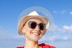 Young adult beautiful happy attractive caucasian woman portrait in sunglasses and hat enjoy looking far away and smiling