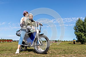 Young adult beautiful mother and daughter enjoy having fun riding electric scooter bike or rural countryside dirt road