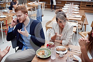Young adult businesspeople at lunch in a restaurant discussing about issues after coronavirus. recesion, economy, business