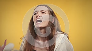 Young adult caucasian woman is feeling anxious on a bright yellow background in studio