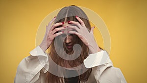 Young adult caucasian woman is feeling anxious on a bright yellow background in studio