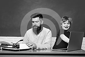 Young adult concept. Father and son typing on old typewriter and laptop. Old and young people. Technology progress.