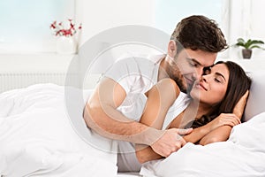 Young adult couple in bedroom photo