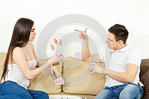 Young adult couple fight over stupid card game