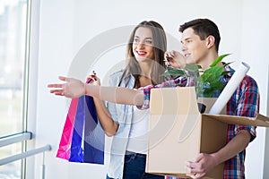 Young Adult Couple Inside Room with Boxes Holding New House Keys