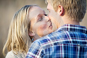 Young adult couple kissing outside in daytime